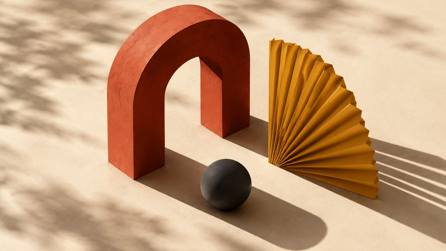 A vermilion arch, charcoal sphere and mustard paper fan cast long geometric shadows on an ivory surface.